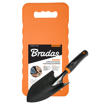 Black wide hand trowel beside an orange Bradas foam kneeling mat with a carry opening.